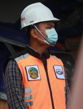 man in orange vest wearing white helmet